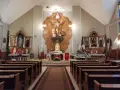 Wnętrze kościoła z ołtarzem głównym i ławkami. Warto wiedzieć, co odpowiedzieć na szczęść boże, gdy się wchodzi do takiej świątyni.
