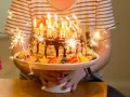 Urodzinowy tort z ogniem i owocami, idealny na mądre życzenia urodzinowe dla zięcia.