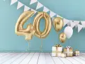 Złote balony z cyfrą 40 i prezenty. Idealne życzenia na 40 urodziny dla córki, pełne blasku i radości!