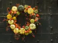 Jesienny wianek z dyni, miechunki i czerwonych jagódek. Inspiracja, jak zrobić wianek na drzwi.