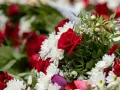 Napis na szarfie pogrzebowej dla brata: "Kochany Braciszku, na zawsze w sercu". Bukiet czerwonych róż i białych chryzantem.