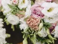 Delikatne, pastelowe rodzaje bukietów we florystyce: białe róże, pudrowy goździk i różana róża tworzą romantyczną kompozycję.