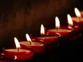 Płonące świece w czerwonych naczyniach, symbolizujące kondolencje po angielsku.