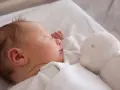 Słodki chłopczyk śpi obok białej przytulanki. Gratulacje z okazji narodzin syna!