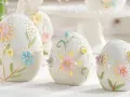 Białe, ceramiczne jajka z pastelowymi kwiatami i listkami, ozdobione ażurowymi wzorami. Te piękne symbole wielkanocne tworzą magiczną atmosferę.