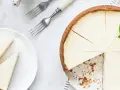 Sernik na 22 rocznicę ślubu, udekorowany miętą. Obok talerz z dwoma kawałkami ciasta i cytryna.