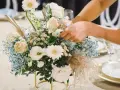 Delikatne, białe i kremowe kwiaty, gipsówka i niebieskie akcenty tworzą kompozycję. Idealne, jakie kwiaty na chrzest na stół.