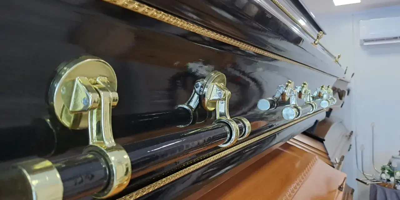 Elegancka, czarna trumna z ozdobnymi uchwytami. Warto pomyśleć, jak napisać pożegnanie od zmarłego, by oddać mu hołd.