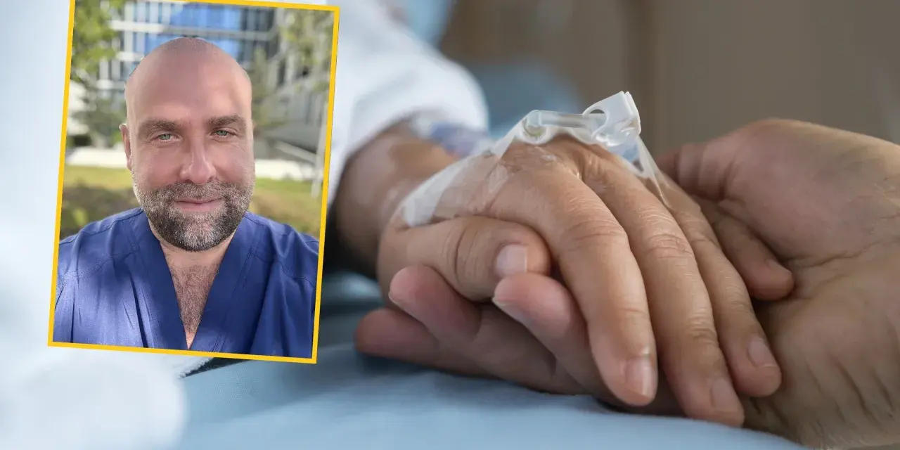 Uśmiechnięty mężczyzna w niebieskim uniformie medycznym dodaje słowa otuchy dla chorego, trzymając go za rękę.