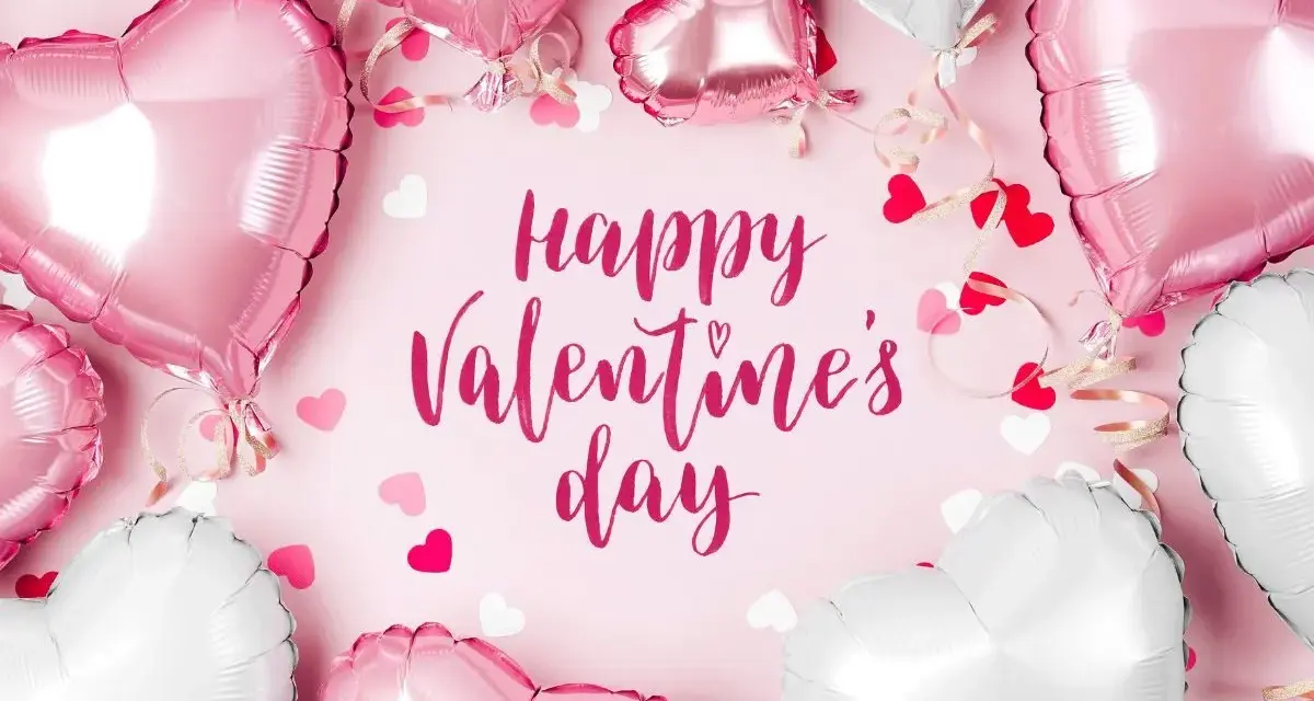 Mnóstwo różowych i białych balonów w kształcie serc, ozdobionych wstążkami i konfetti, tworzy romantyczną atmosferę. Napis "Happy Valentine's Day" dopełnia całość.