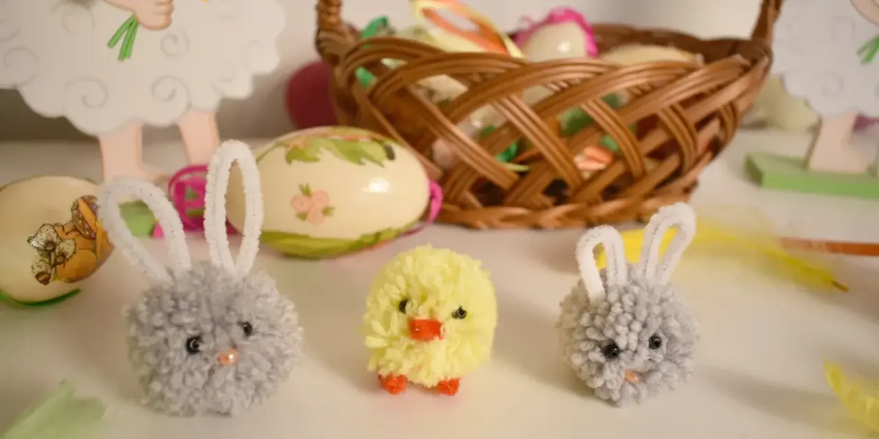 Urocze, proste ozdoby wielkanocne: puchate zajączki i kurczaczek, obok koszyka z pisankami.