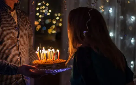 Urodzinowy tort ze świeczkami dla 14 latki, w tle migoczące światełka.