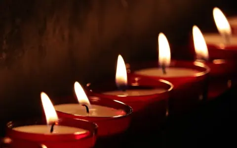 Płonące świece w czerwonych naczyniach, symbolizujące kondolencje po angielsku.
