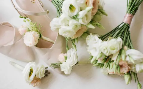 Eleganckie, jasne buty ślubne i mały bukiet do ślubu cywilnego z delikatnymi różami i eustomą.