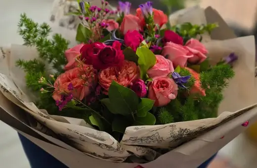 Piękny bukiet róż i innych kwiatów, idealny jako prezent. Jakie kwiaty dla starszej osoby? Te delikatne, pastelowe róże z pewnością ucieszą.