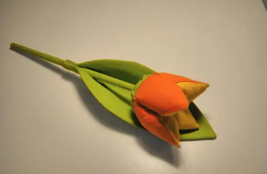 Pomarańczowo-żółty tulipan z zielonym liściem, jak suszyć tulipany, by zachować ich piękno.