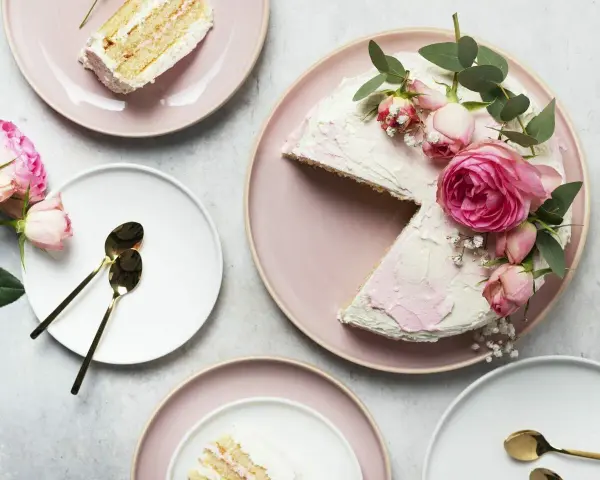 Elegancki tort udekorowany żywymi kwiatami róż i gałązkami eukaliptusa. Idealny pomysł, kiedy udekorować tort żywymi kwiatami na specjalną okazję.