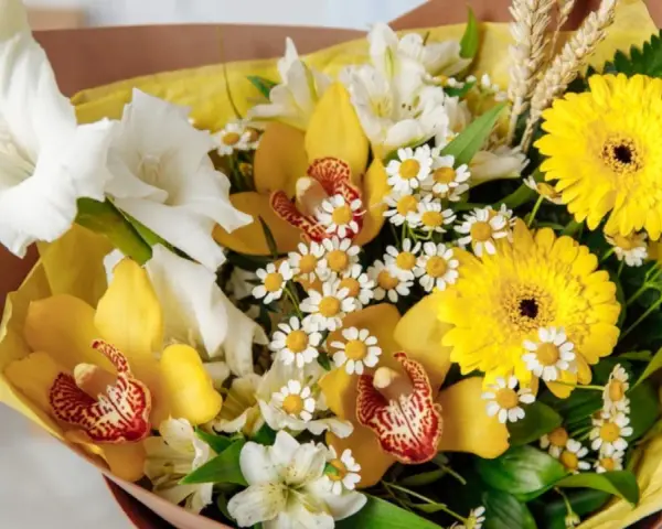 Bukiet pełen słońca: żółte kwiaty symbolizują radość i przyjaźń. Gerbery, cymbidium i mieczyki tworzą radosną kompozycję.