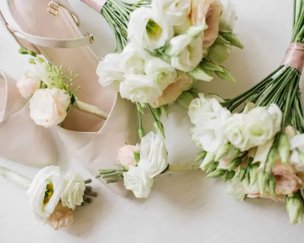 Eleganckie, jasne buty ślubne i mały bukiet do ślubu cywilnego z delikatnymi różami i eustomą.