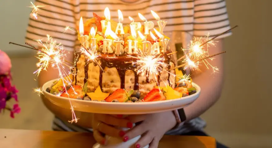Urodzinowy tort z ogniem i owocami, idealny na mądre życzenia urodzinowe dla zięcia.