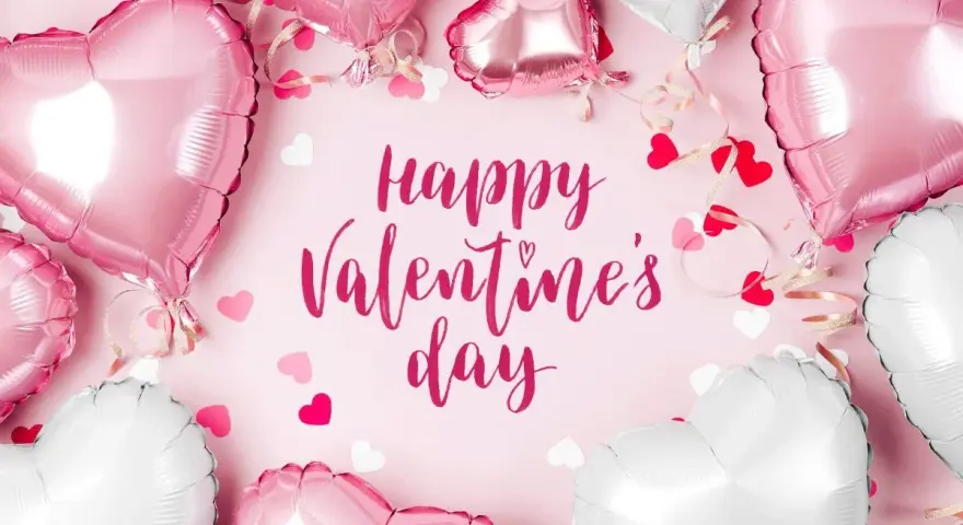 Mnóstwo różowych i białych balonów w kształcie serc, ozdobionych wstążkami i konfetti, tworzy romantyczną atmosferę. Napis "Happy Valentine's Day" dopełnia całość.