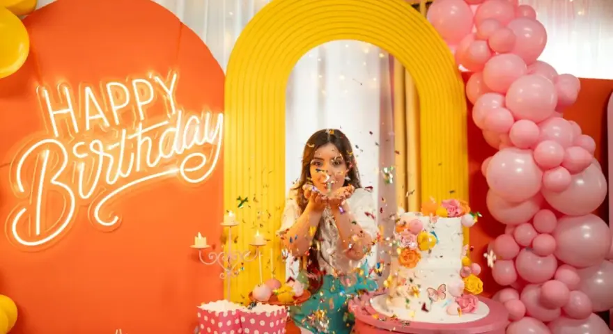 Kolorowe przyjęcie urodzinowe z neonowym napisem "Happy Birthday", tortem i konfetti. Fajne pomysły na urodziny dla nastolatków!