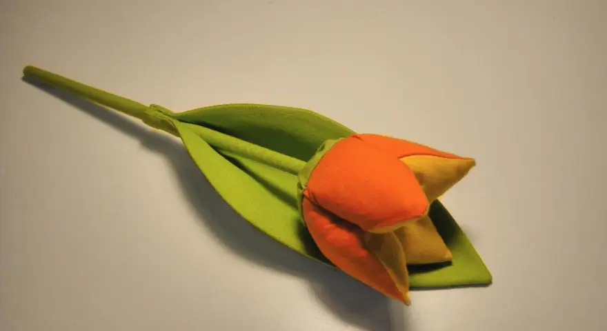 Pomarańczowo-żółty tulipan z zielonym liściem, jak suszyć tulipany, by zachować ich piękno.