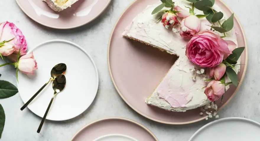 Elegancki tort udekorowany żywymi kwiatami róż i gałązkami eukaliptusa. Idealny pomysł, kiedy udekorować tort żywymi kwiatami na specjalną okazję.