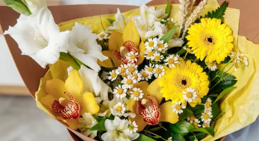 Bukiet pełen słońca: żółte kwiaty symbolizują radość i przyjaźń. Gerbery, cymbidium i mieczyki tworzą radosną kompozycję.