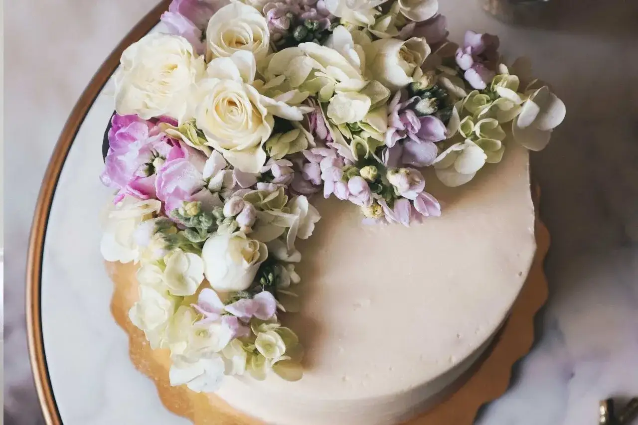 Elegancki tort udekorowany bukietem żywych kwiatów. Idealny pomysł, kiedy udekorować tort żywymi kwiatami na specjalną okazję.